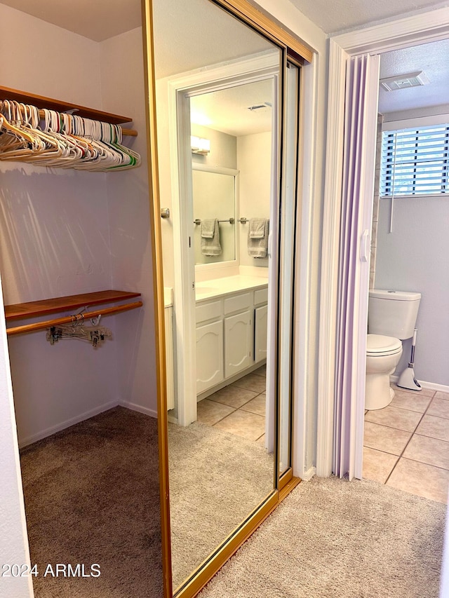 bathroom featuring toilet, vanity, and tile patterned floors