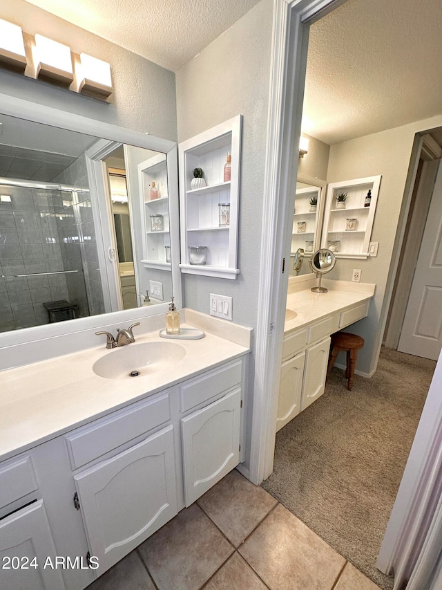 bathroom with walk in shower, tile patterned flooring, vanity, and a textured ceiling