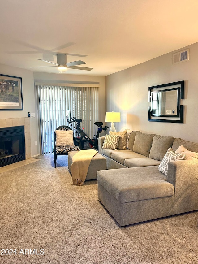 carpeted living room with a fireplace and ceiling fan