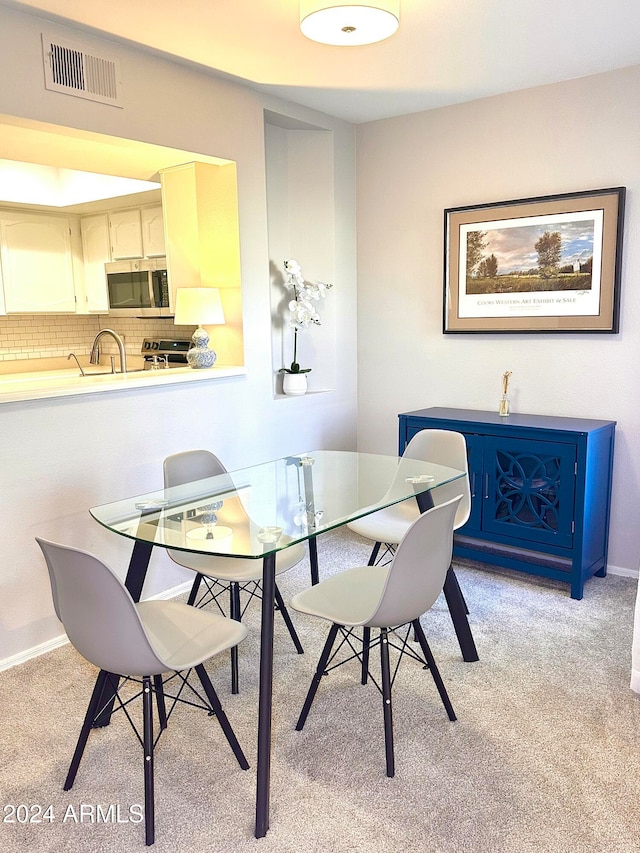 dining room featuring light carpet