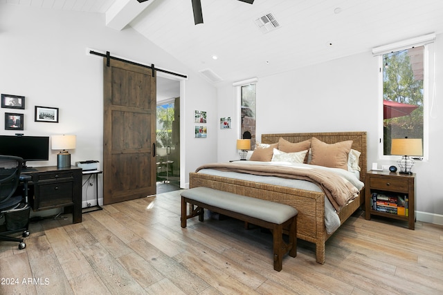 bedroom with a barn door, lofted ceiling with beams, light wood-type flooring, and ceiling fan