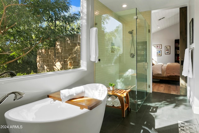 bathroom featuring lofted ceiling, shower with separate bathtub, and tile patterned flooring