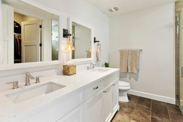 bathroom featuring vanity, toilet, and an enclosed shower