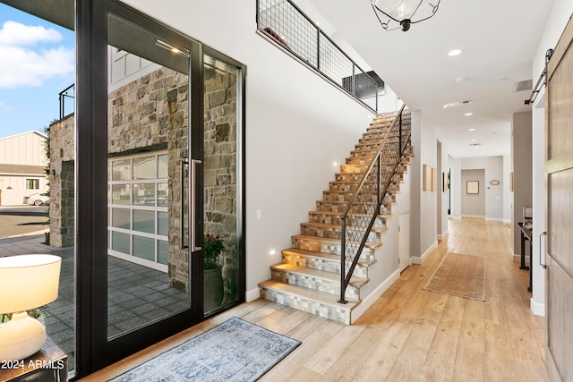 interior space with a healthy amount of sunlight, a barn door, and light wood-type flooring