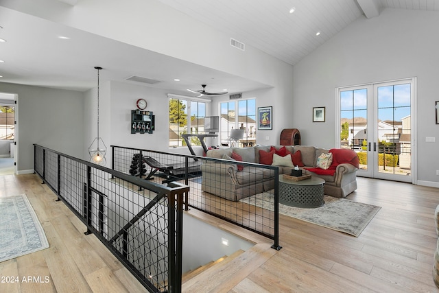 living room with french doors, light hardwood / wood-style floors, ceiling fan, beamed ceiling, and high vaulted ceiling