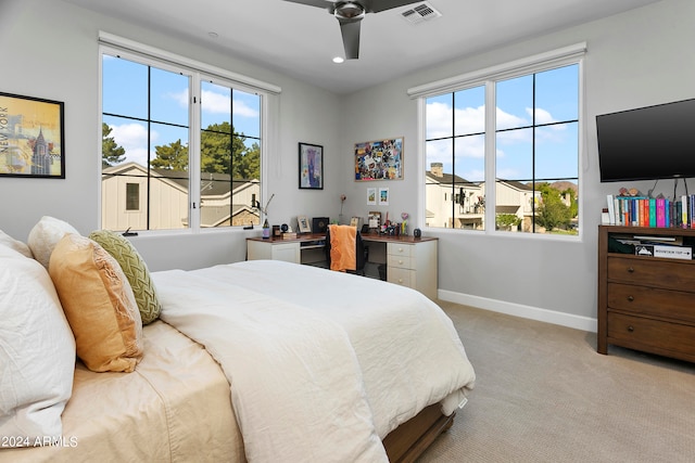 carpeted bedroom with ceiling fan and multiple windows