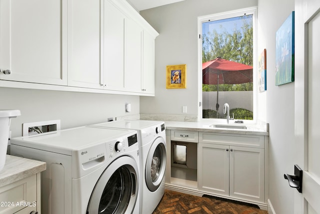 clothes washing area with cabinets, sink, and washing machine and clothes dryer