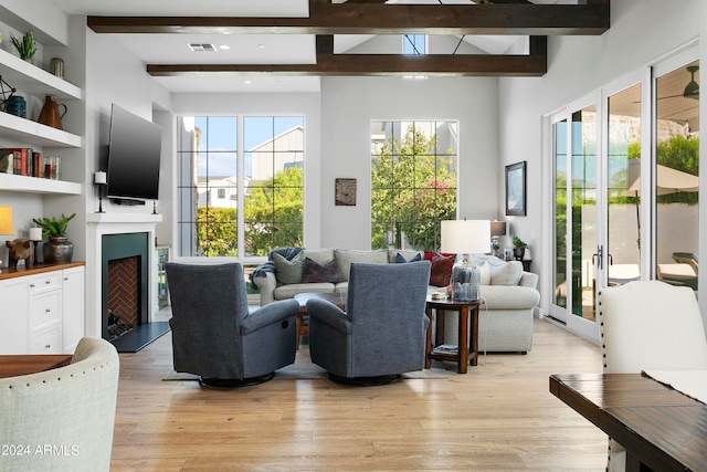 living room featuring beam ceiling and light hardwood / wood-style flooring