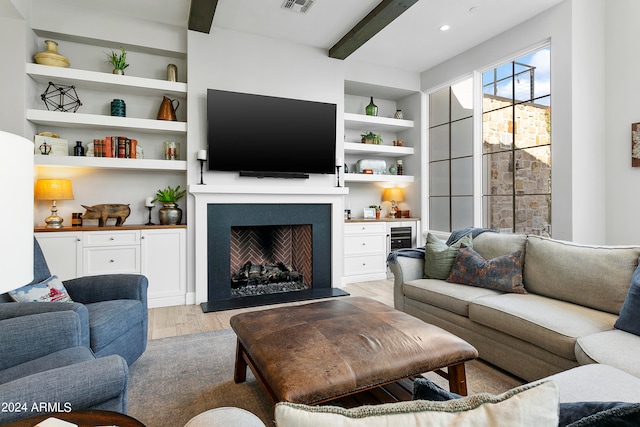 living room with light hardwood / wood-style floors, built in features, and beamed ceiling