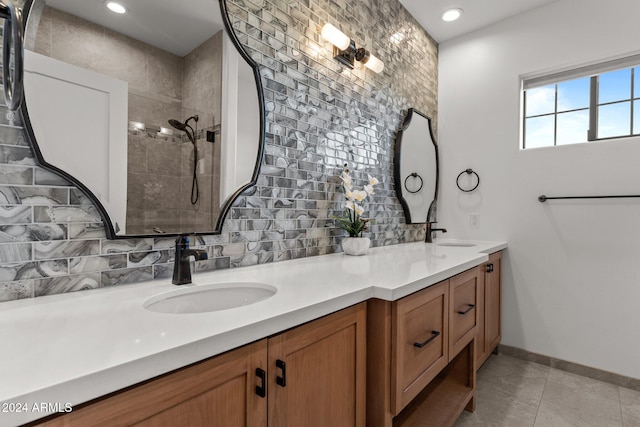 bathroom featuring vanity, decorative backsplash, tile patterned flooring, and a tile shower