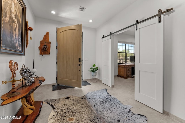 foyer entrance with a barn door and light tile patterned flooring