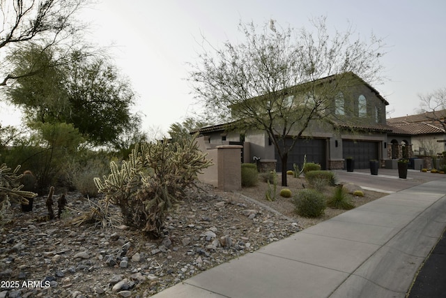 view of front of home featuring concrete driveway and stucco siding