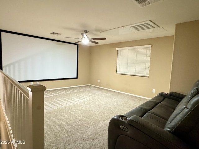 home theater room with ceiling fan and light colored carpet