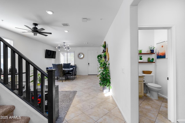 interior space with ceiling fan with notable chandelier and tile patterned flooring