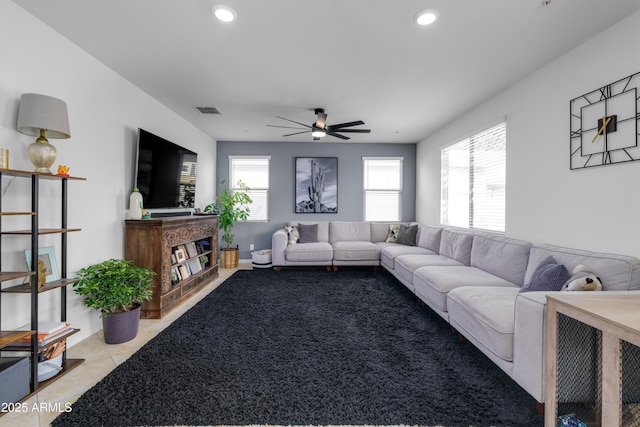 living room with light tile patterned floors, a healthy amount of sunlight, and ceiling fan