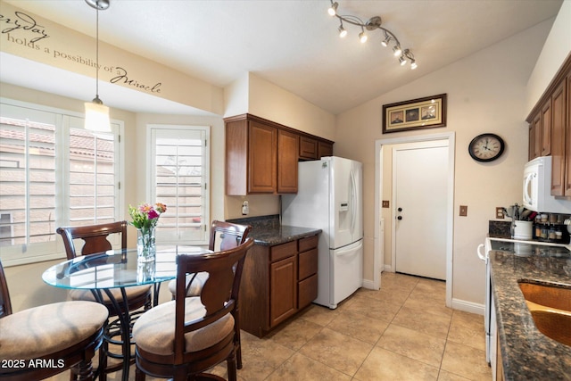 kitchen featuring vaulted ceiling, pendant lighting, plenty of natural light, and white appliances