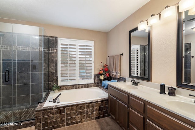 bathroom with vanity and shower with separate bathtub