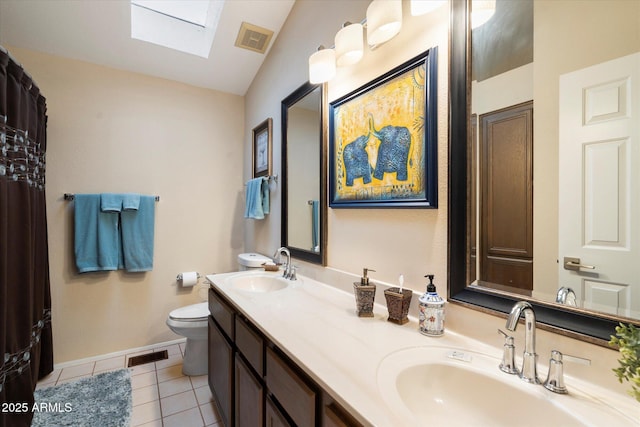 bathroom featuring toilet, vaulted ceiling with skylight, tile patterned floors, and vanity