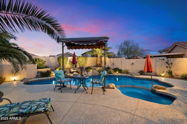 pool at dusk with a patio area