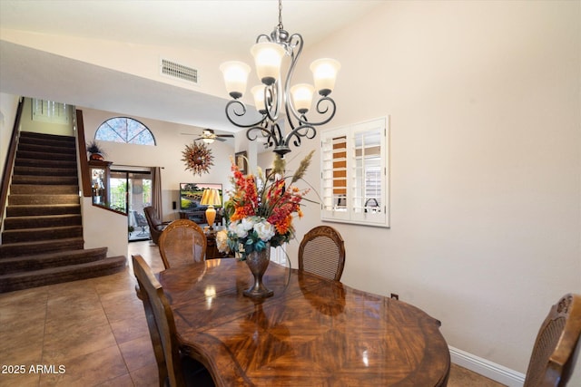 dining room featuring vaulted ceiling, tile patterned floors, and ceiling fan with notable chandelier