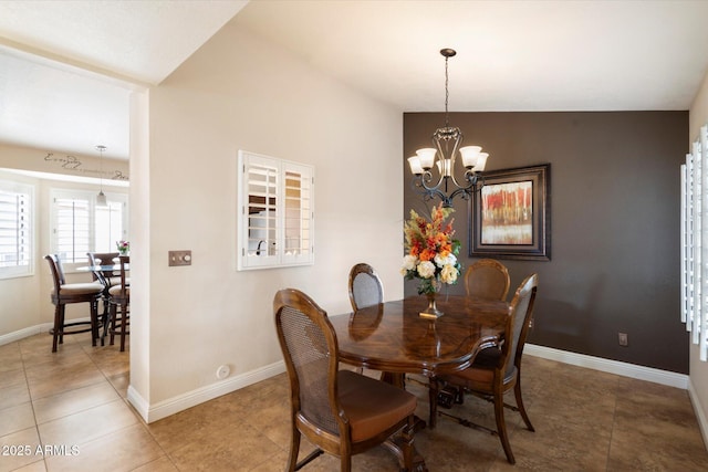 dining space featuring vaulted ceiling, a chandelier, and tile patterned floors