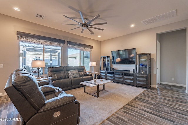 living room featuring ceiling fan and dark hardwood / wood-style flooring