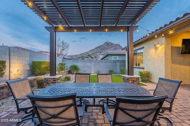 patio terrace at dusk featuring a pergola and a mountain view