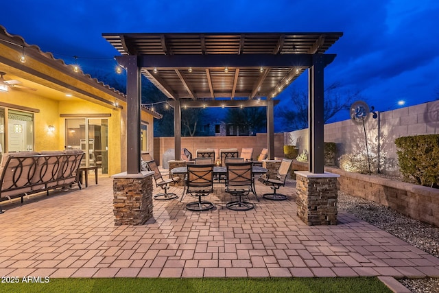 patio at night featuring a pergola