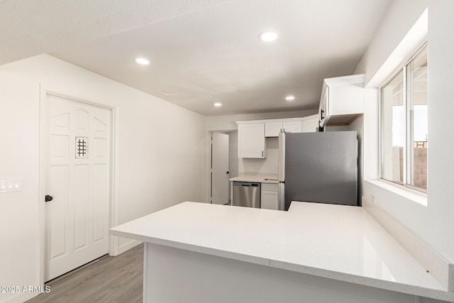 11842 N 30th Dr, Phoenix, AZ 85029 - kitchen with light wood-style floors, a peninsula, recessed lighting, white cabinetry, and stainless steel appliances