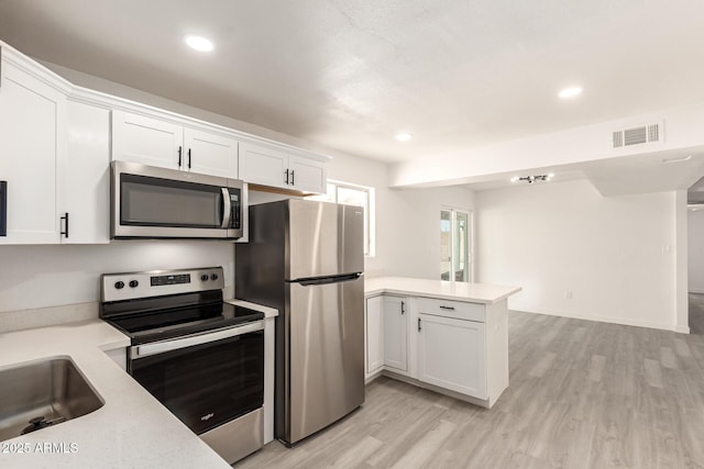 11842 N 30th Dr, Phoenix, AZ 85029 - kitchen featuring a peninsula, appliances with stainless steel finishes, light countertops, and visible vents