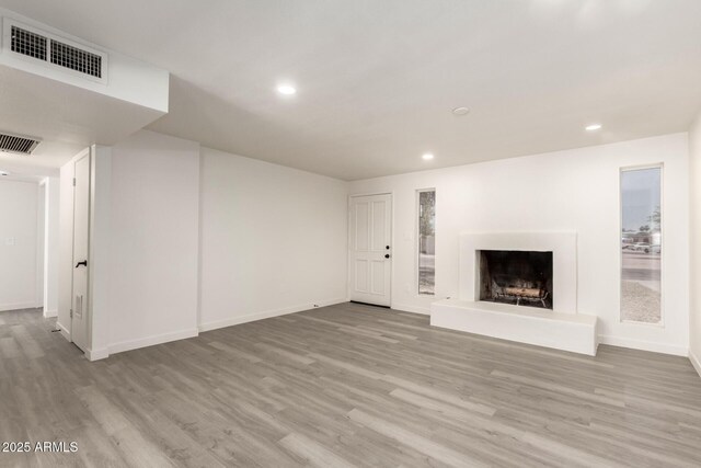11842 N 30th Dr, Phoenix, AZ 85029 - unfurnished living room featuring wood finished floors, a fireplace with raised hearth, visible vents, and recessed lighting