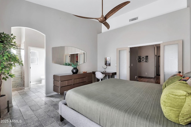 bedroom featuring ceiling fan, ensuite bathroom, and vaulted ceiling