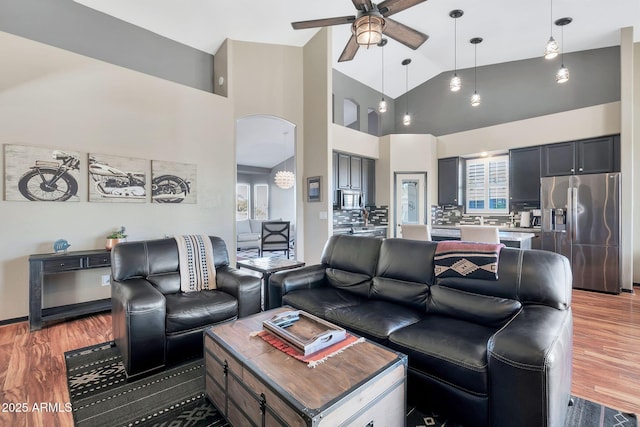 living room with ceiling fan, dark hardwood / wood-style floors, and high vaulted ceiling