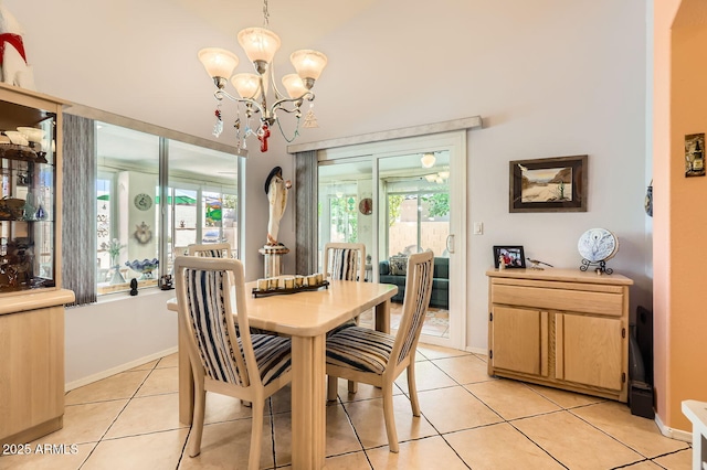 dining space featuring baseboards, light tile patterned floors, and an inviting chandelier