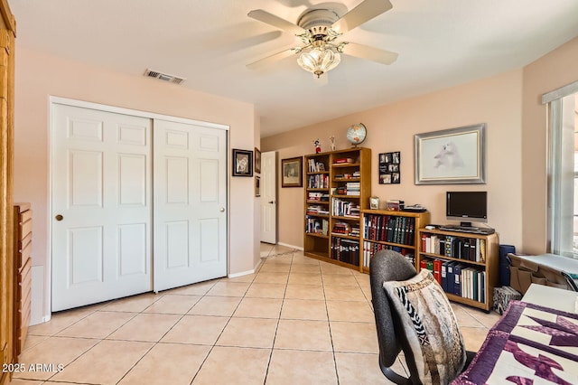 office with light tile patterned floors, visible vents, and a ceiling fan