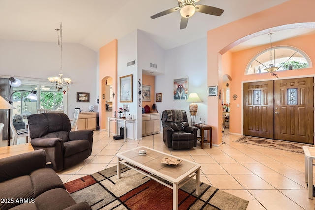 living room featuring light tile patterned floors, visible vents, arched walkways, high vaulted ceiling, and ceiling fan with notable chandelier