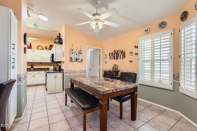 dining room with light tile patterned flooring, ceiling fan, and vaulted ceiling