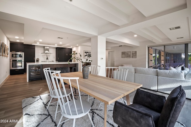 dining space featuring beverage cooler, beam ceiling, and dark wood-type flooring