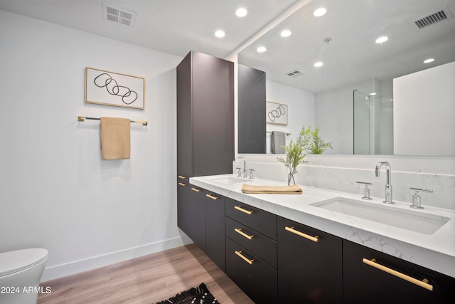 bathroom with hardwood / wood-style floors, an enclosed shower, vanity, and toilet