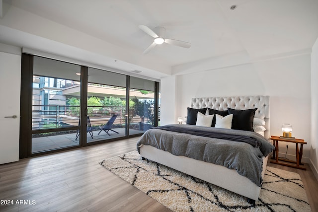 bedroom featuring floor to ceiling windows, light hardwood / wood-style floors, access to exterior, and ceiling fan