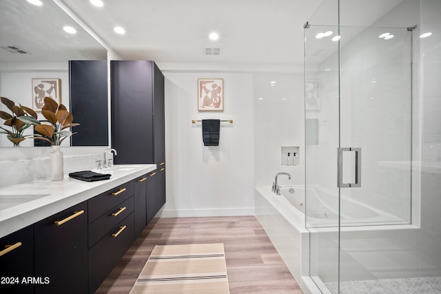 bathroom featuring plus walk in shower, hardwood / wood-style flooring, and vanity