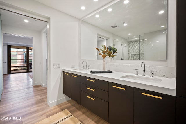 bathroom featuring wood-type flooring, vanity, and a shower with shower door