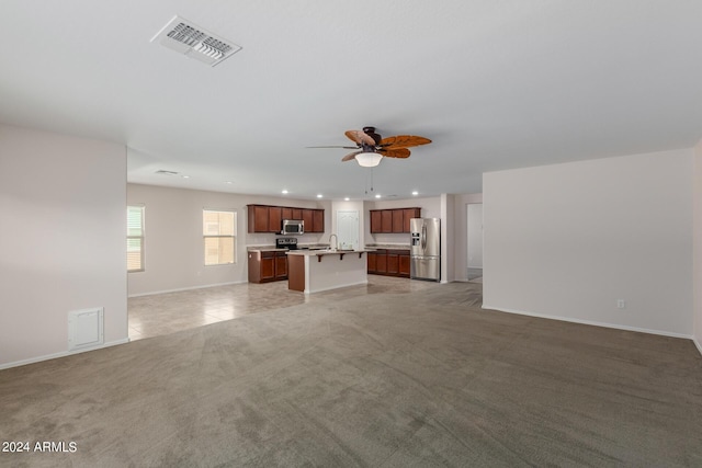 unfurnished living room featuring ceiling fan, sink, and light carpet