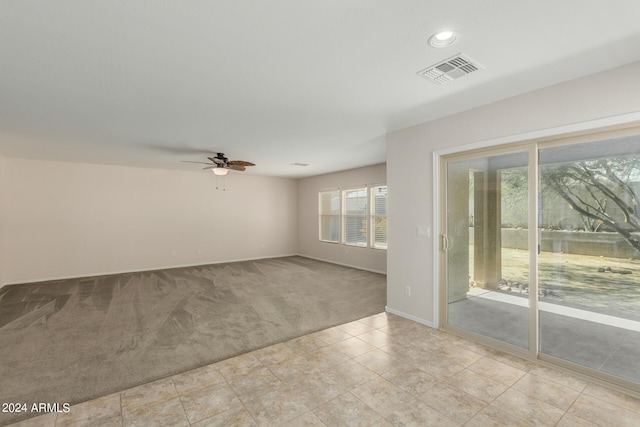 empty room featuring ceiling fan and light colored carpet