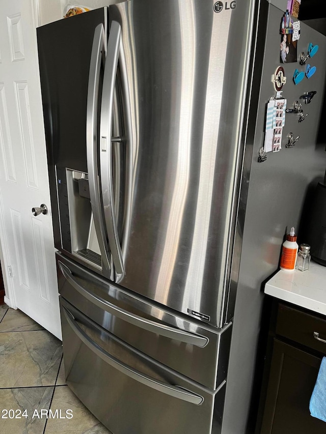 room details with stainless steel fridge and light tile patterned floors