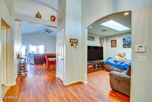 hall with vaulted ceiling with skylight and wood-type flooring