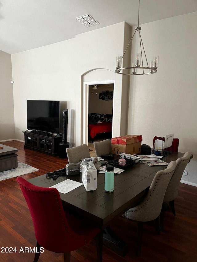 dining area with dark hardwood / wood-style floors and a chandelier