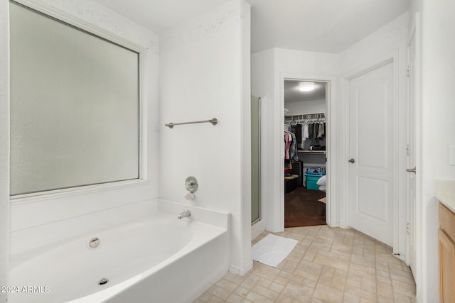 bathroom featuring tile patterned flooring, vanity, and shower with separate bathtub