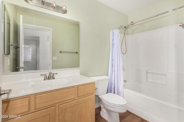 full bathroom with hardwood / wood-style floors, toilet, shower / bath combo with shower curtain, and vanity