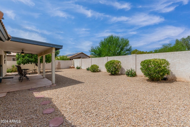 view of yard with ceiling fan and a patio area